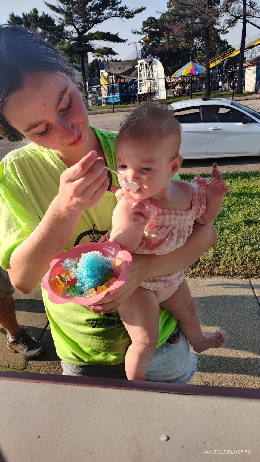 A happy little customer enjoying a colorful Icy Cone at an event