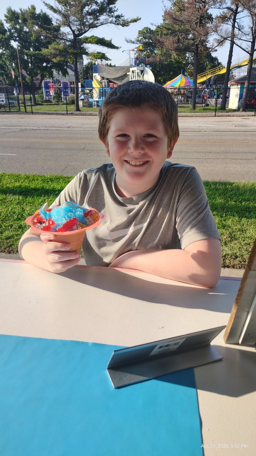 A smiling customer enjoying a colorful Pourz n Popz Icy Cone