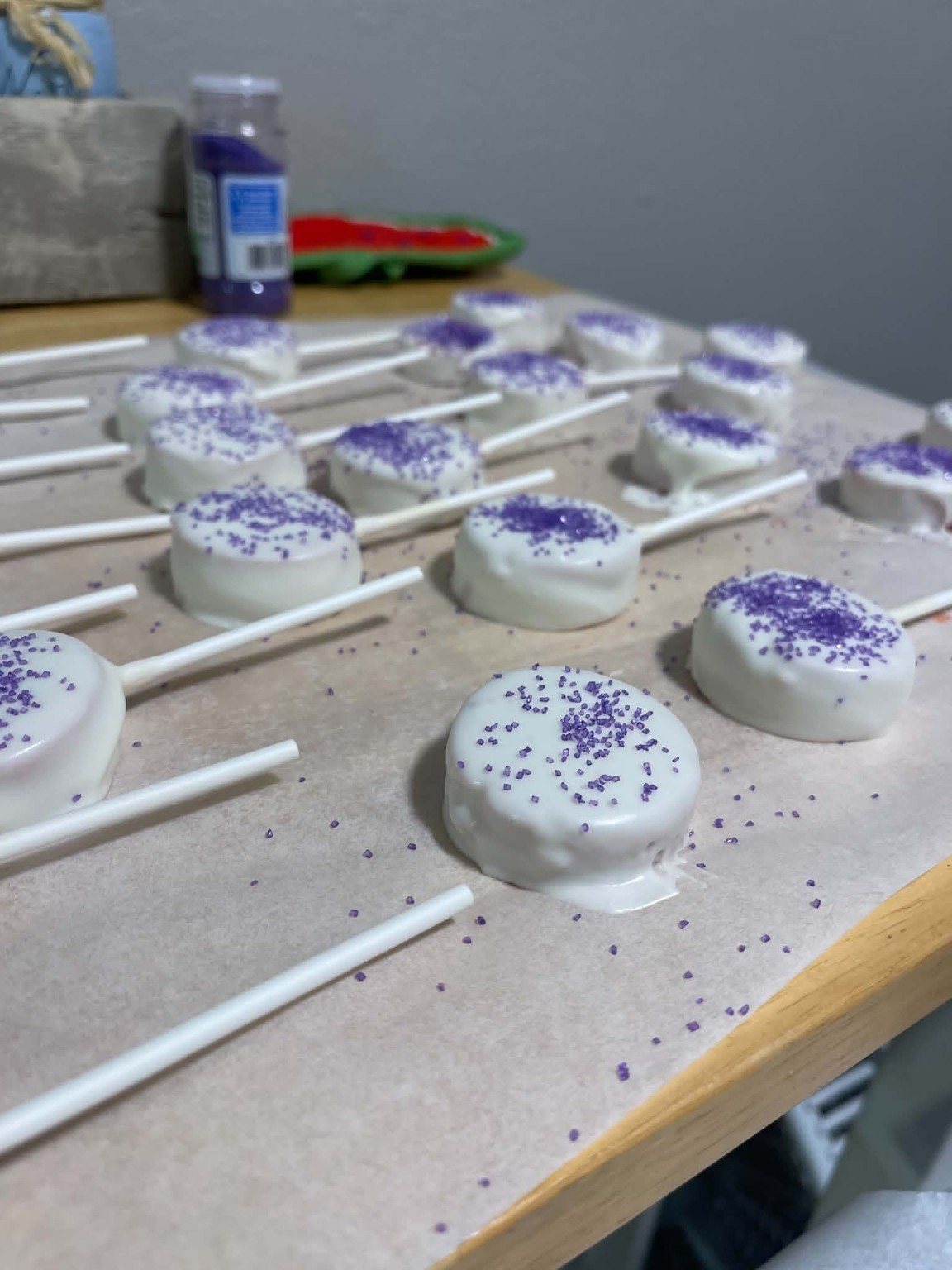 White cake pops finished with purple sugar sprinkles